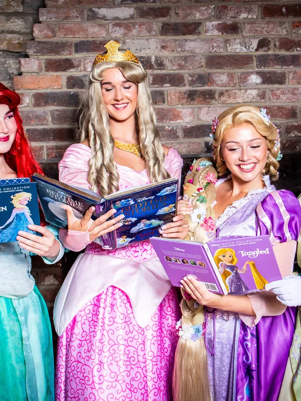 Four princess performers reading storybooks together