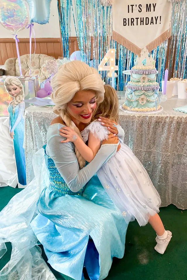Ice Queen performer hugging a birthday girl at her party